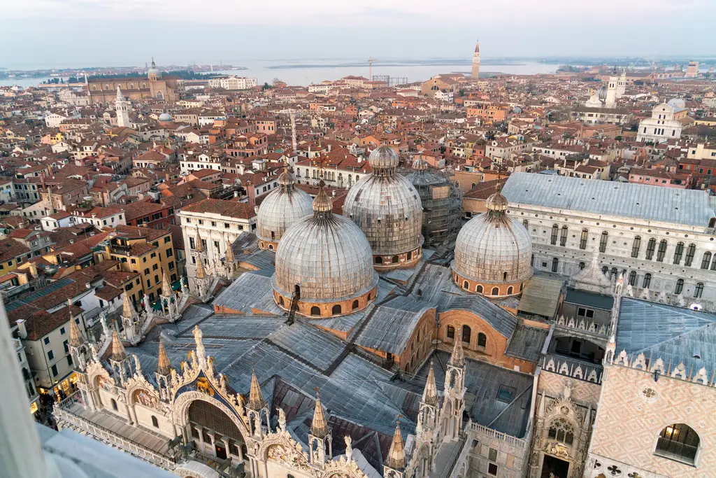 The domes of St Mark’s from above, beside the Doge’s Palace, with the city and the lagoon behind